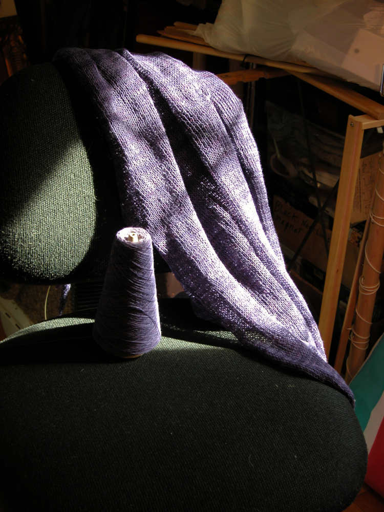 KewlCat Designs First Machine Knit Garment on Chair. Sunlight is casting dramatic shadows
